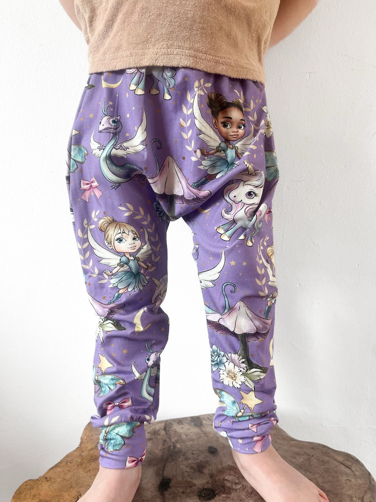 Kids harem pants with purple fairyland print including fairies, unicorns, and dragons