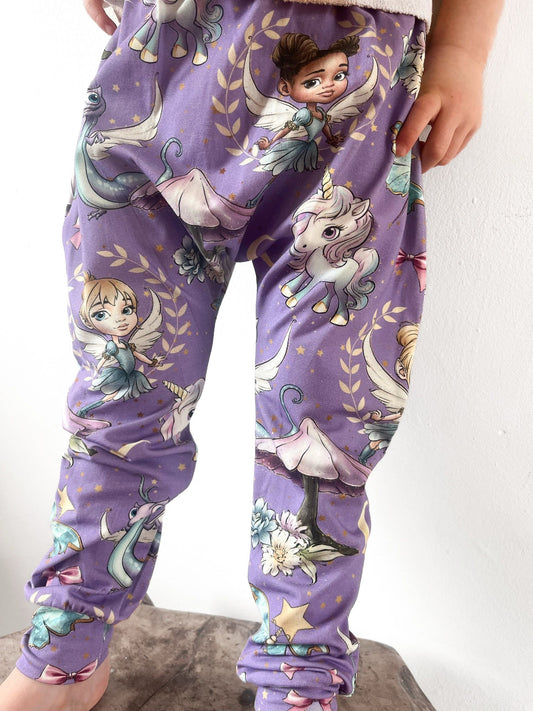 Kids harem pants with purple fairyland print including fairies, unicorns, and dragons